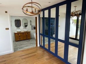 Bespoke painted fitted wardrobe in Surrey bedroom with mirrored doors